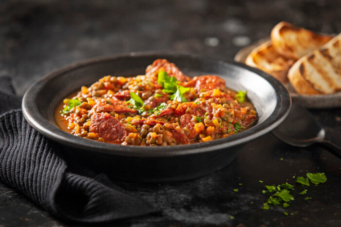 Grilled chorizo with green lentils, garlic and tomato